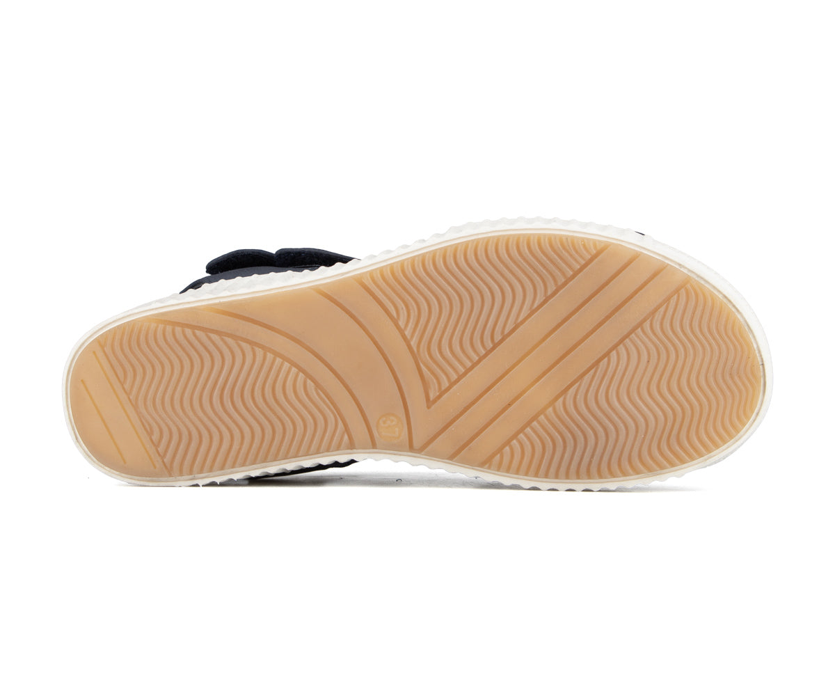 Shoe sole with tan rubber and white border, ribbed and v-shaped tread.
