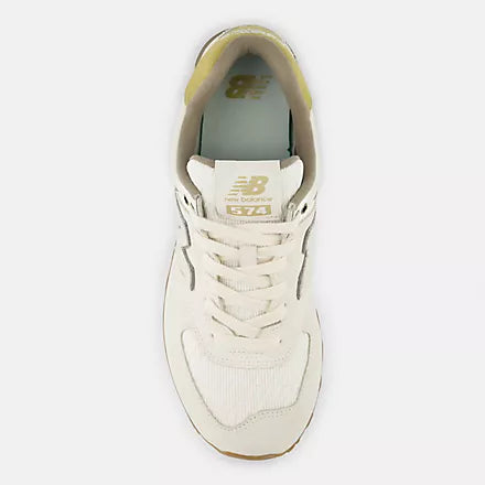 A top-down view of a cream-colored sneaker with light-tan laces and a light-tan interior.