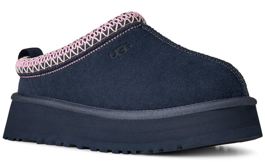 A navy blue suede slipper with a pink and white zig-zag trim around the opening sits atop a thick, navy blue platform sole.