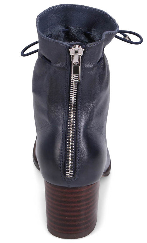 Back view of navy blue leather bootie with a silver back zipper and a stacked block heel.