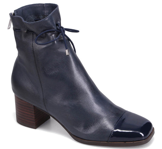 Navy blue leather boot with a stacked heel, square toe with patent leather detail, and a drawstring around the ankle.