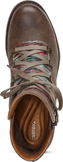 Top-down view of a brown, lace-up boot with an inner brown insole and a patterned fabric under the laces.