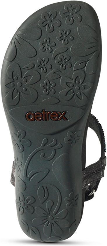 The sole of a sandal with flower and leaf pattern. The brand name "aetrex" is visible.