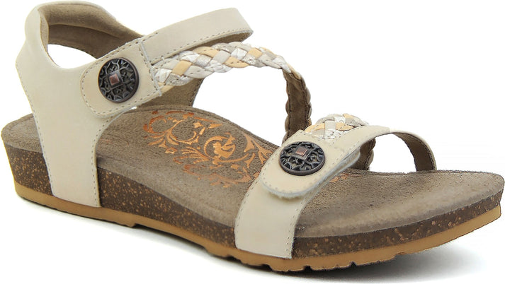 Beige sandal with braided straps and decorative metallic buttons.