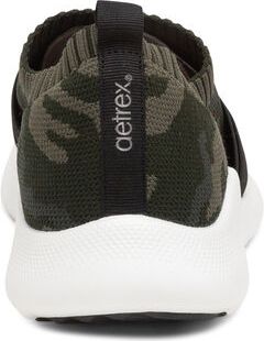 Olive camouflage slip-on shoe with white sole and black accents, featuring a prominent "aetrex" tag on the heel.