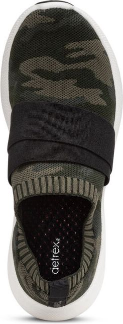 Top-down view of a camo slip-on shoe with a black strap and a white sole.