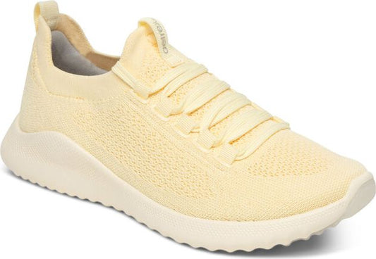 Knit athletic shoe with light yellow upper and laces.