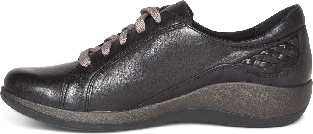 A black leather sneaker with woven detailing on the heel.