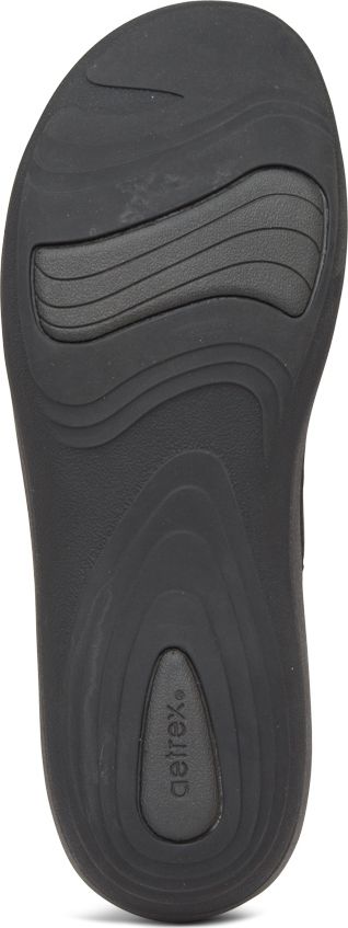 The sole of a black shoe with a repeating geometric pattern.