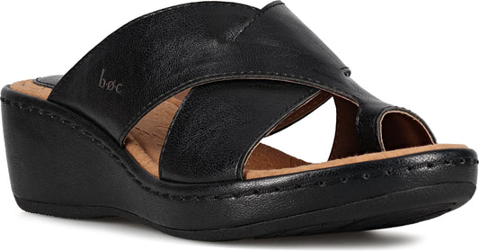 Black slide sandal with crossover straps and a low wedge heel.