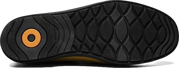 The sole of a shoe has a patterned tread. The heel has a round inset.