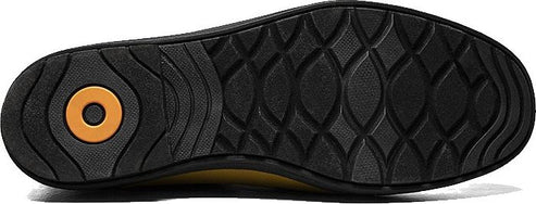 The sole of a shoe has a patterned tread. The heel has a round inset.