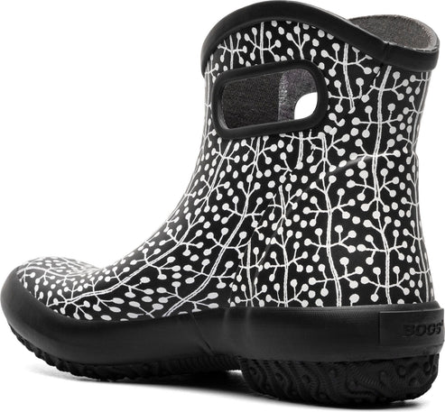 Low black rain boot with a white plant pattern and a handle cutout.