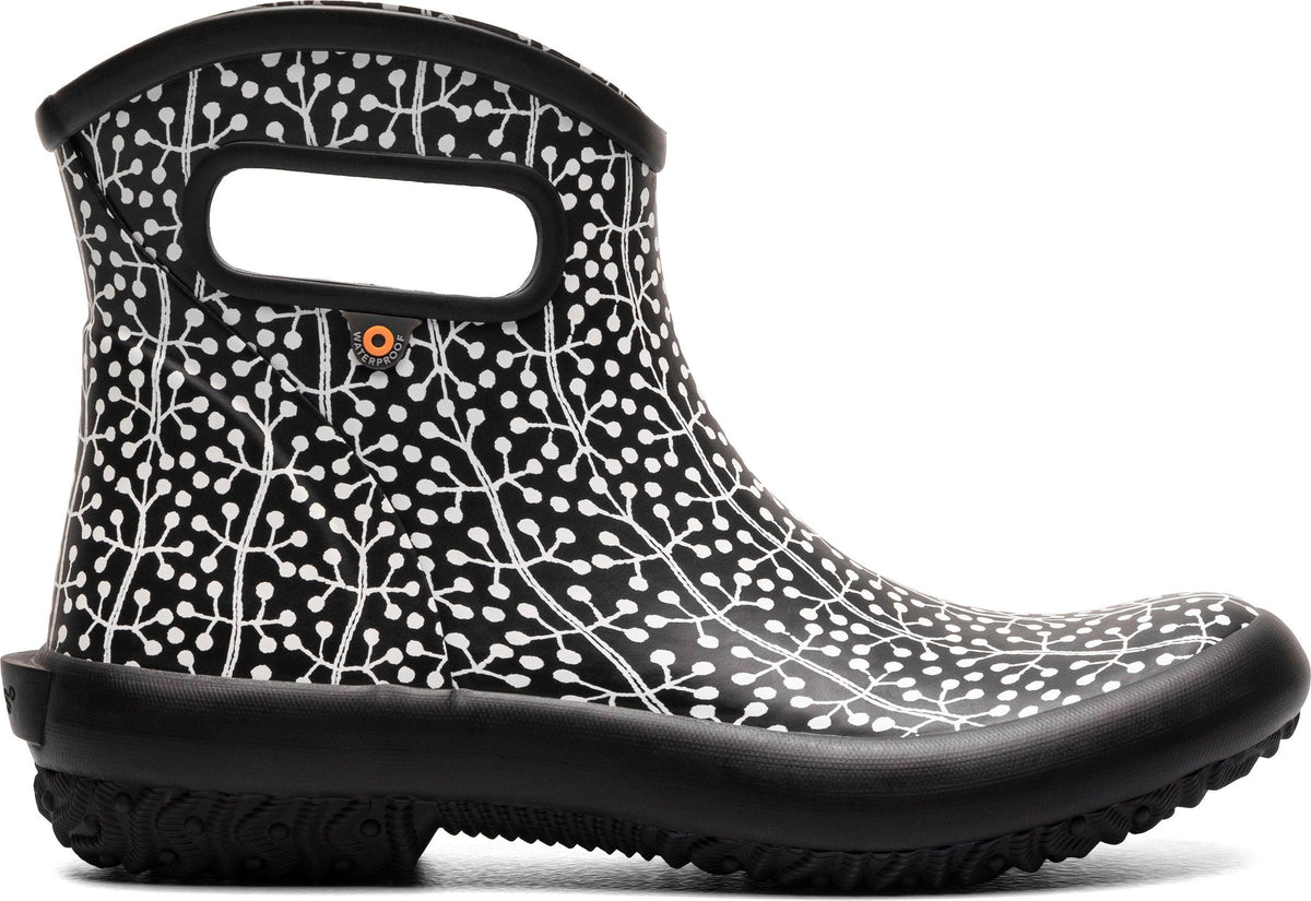 Black ankle boot with a white botanical-inspired print, featuring a low heel and cutout handles.