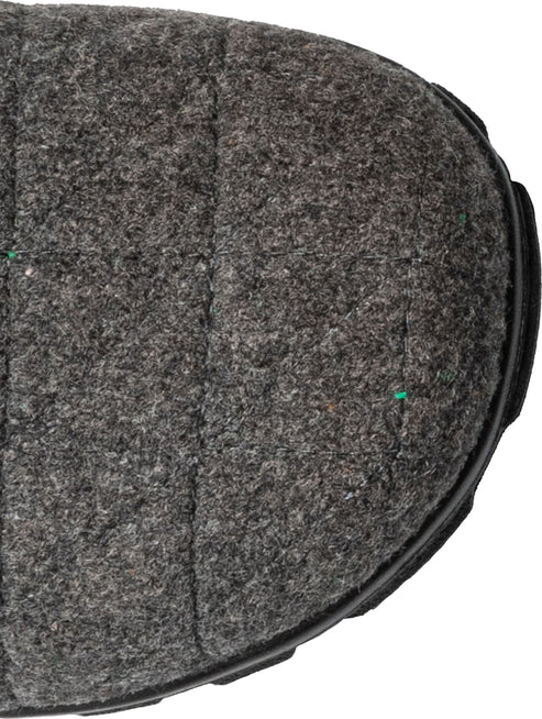 Close-up of gray, felt boot toe with black sole.