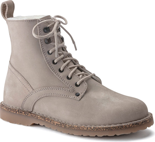 Lace-up combat boot with a suede upper, eyelets, and a cork sole.