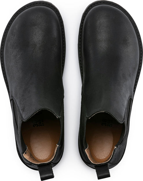 Two identical black Chelsea boots face up with elastic side panels.
