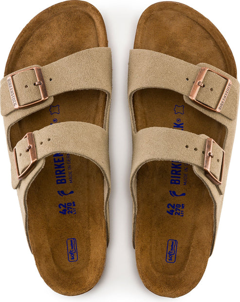 Two light-brown suede sandals with two adjustable straps and copper buckles, lying flat.