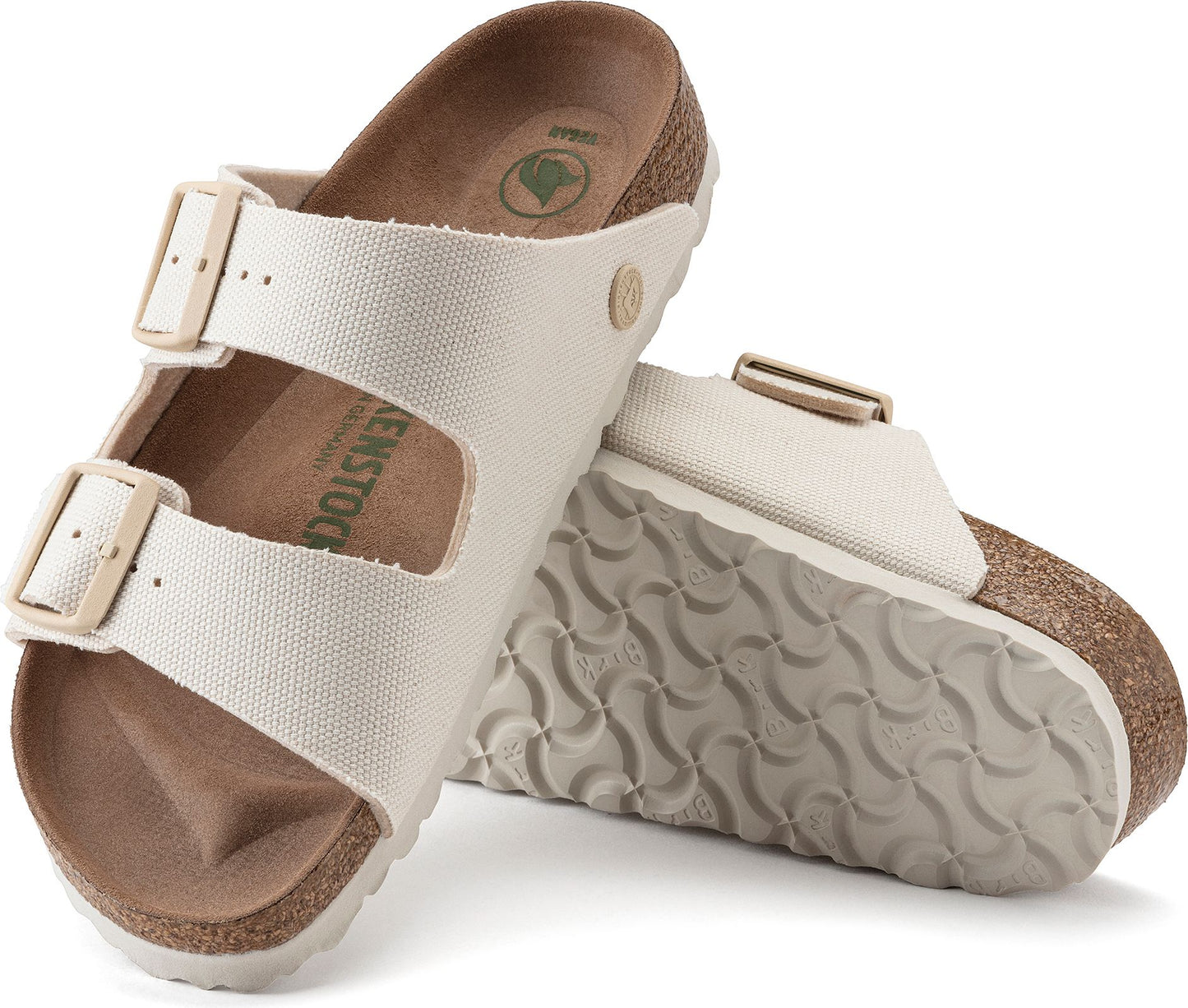 Two white, vegan Arizona double strap sandals are angled to display the soles, straps, and side profile.