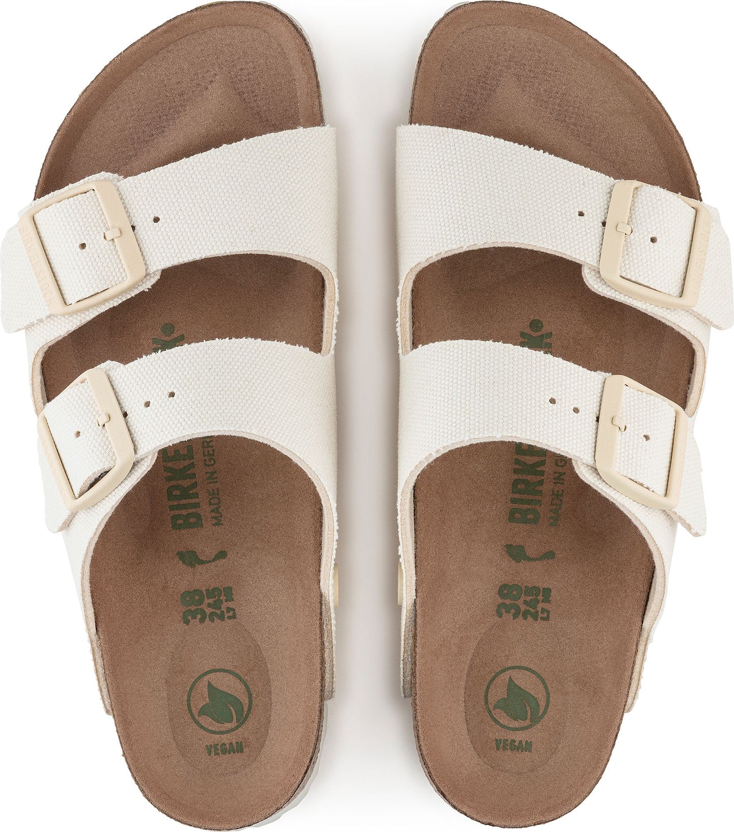 Top-down view of vegan Birkenstock slides in off-white with two adjustable straps, cork footbed, and a vegan logo.