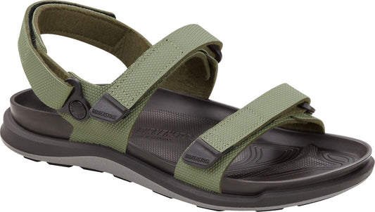 A green sandal with velcro straps and dark brown footbed.