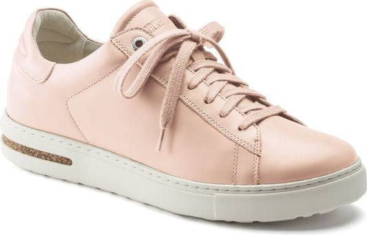 Low-top light pink sneaker with white sole and tied laces.
