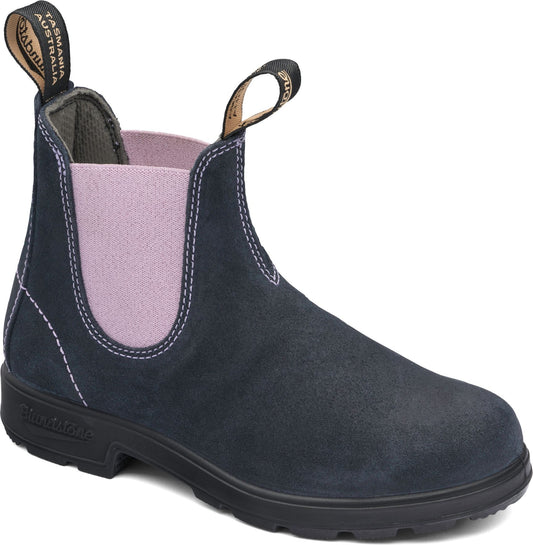 Low-cut Chelsea boot in dark blue suede with visible white stitching, elastic side panels in light purple, and black sole with heel.
