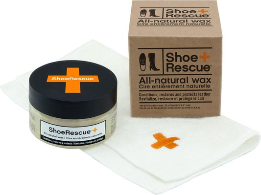 Shoe care kit featuring a jar of wax with a black lid, a cleaning cloth with an orange cross, and a cardboard box.