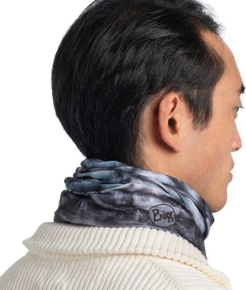 Person with a gray patterned neck warmer and the 'Buff' logo. 
