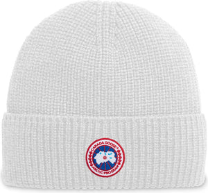 White knit beanie with circular logo featuring a goose and the text 'CANADA GOOSE ARCTIC PROGRAM'.