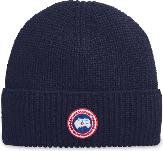 Navy blue knit beanie with a round logo reading "CANADA GOOSE ARCTIC PROGRAM".