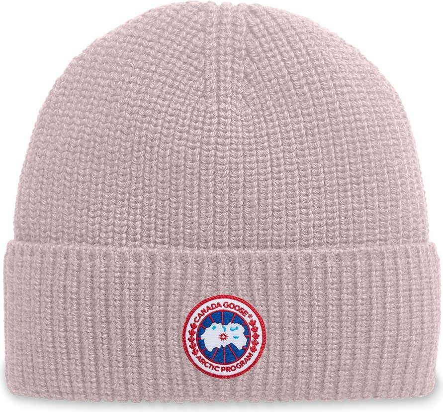 Knit beanie hat in light pink with a circular badge emblem.