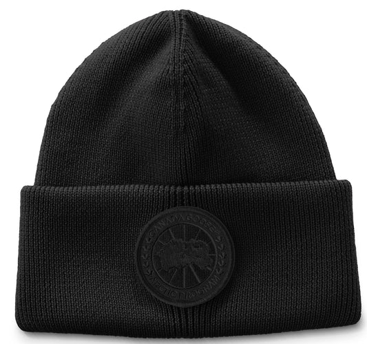 Knit black beanie with circular patch.