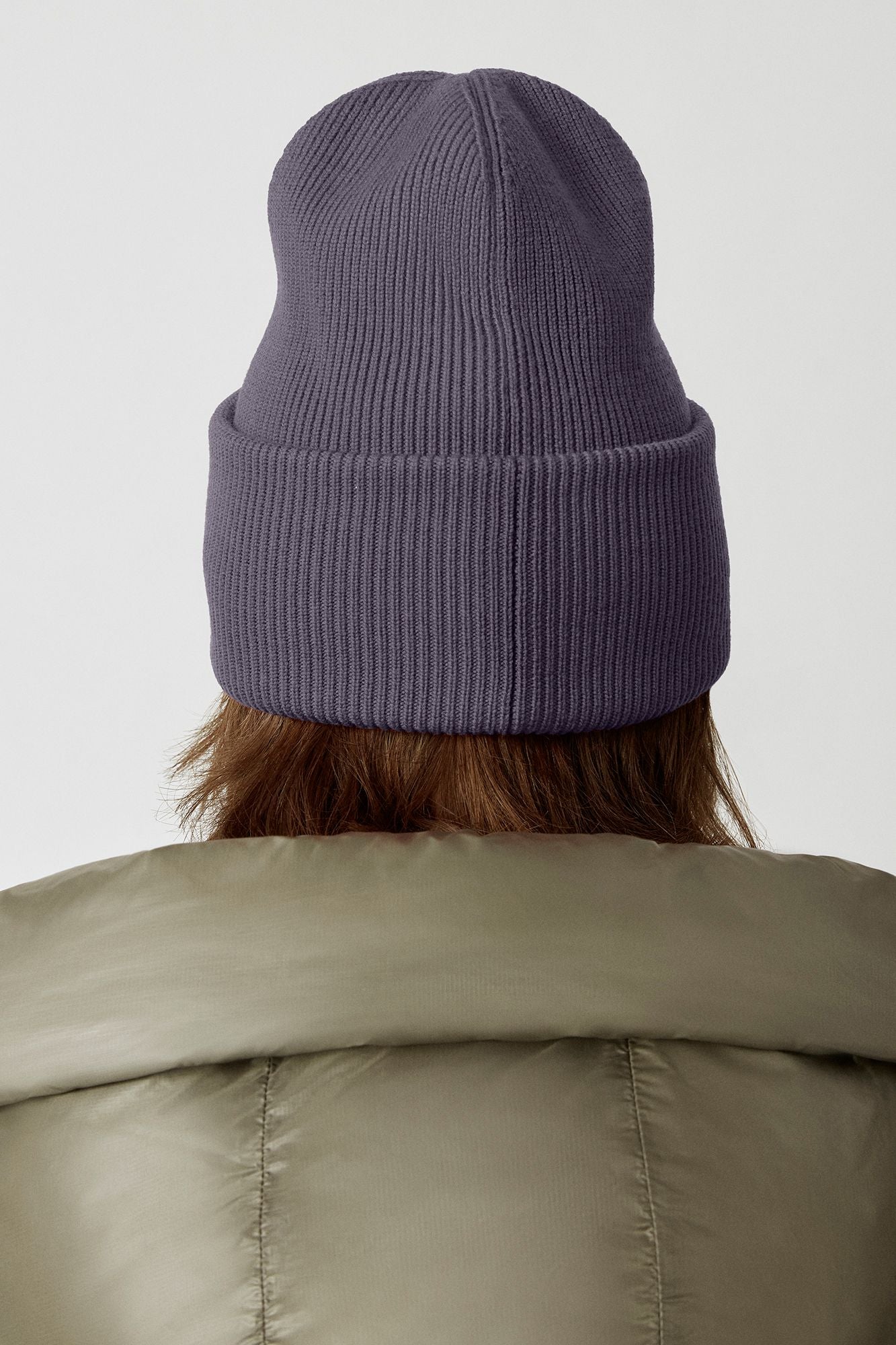 Person wearing a gray ribbed beanie.