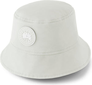 White bucket hat with a round, white emblem on the side.