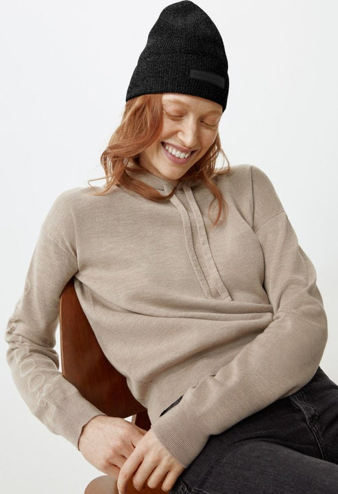 Woman with a black beanie and beige hooded sweater