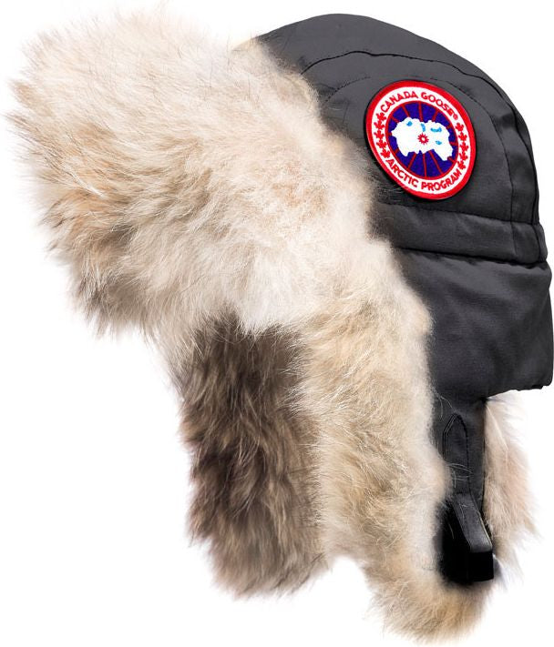 Earflap hat with fur trim and a round badge with the text CANADA GOOSE ARCTIC PROGRAM.