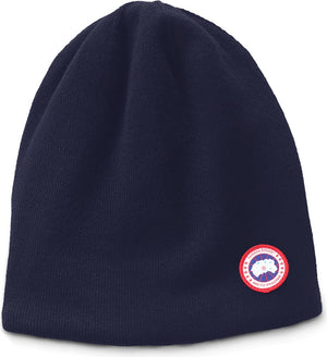 Navy blue beanie hat with a circular emblem on the lower right.