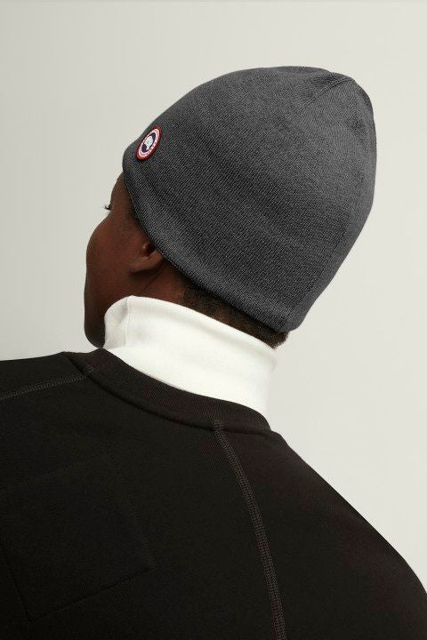 Gray knit beanie with a circular logo.