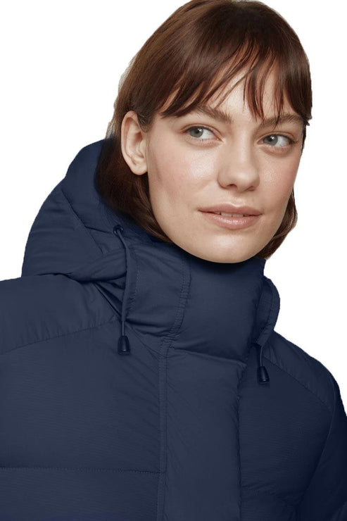 Close-up of a woman in a navy blue hooded puffer jacket.