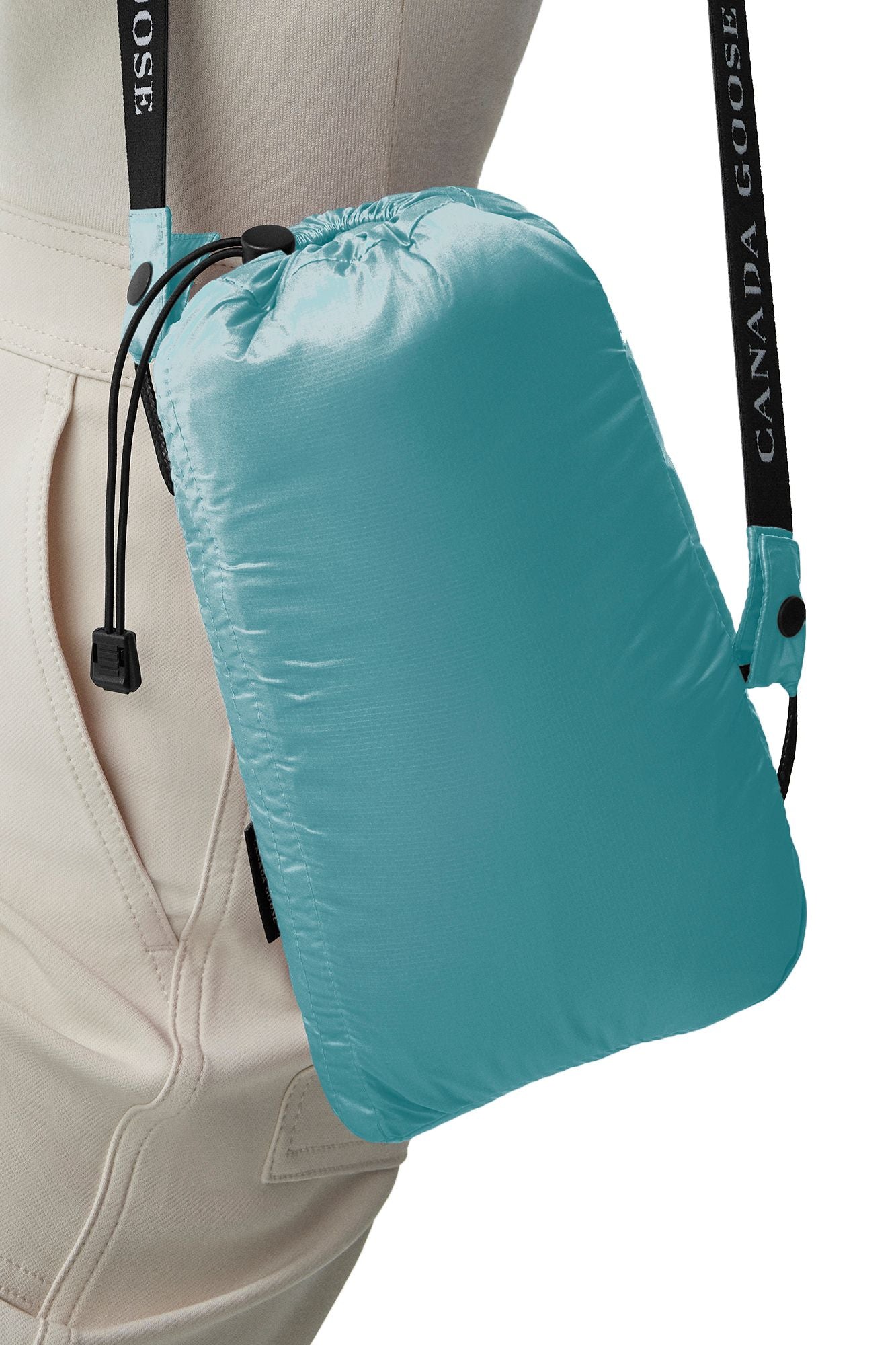 Teal-colored drawstring pouch with branded shoulder strap.