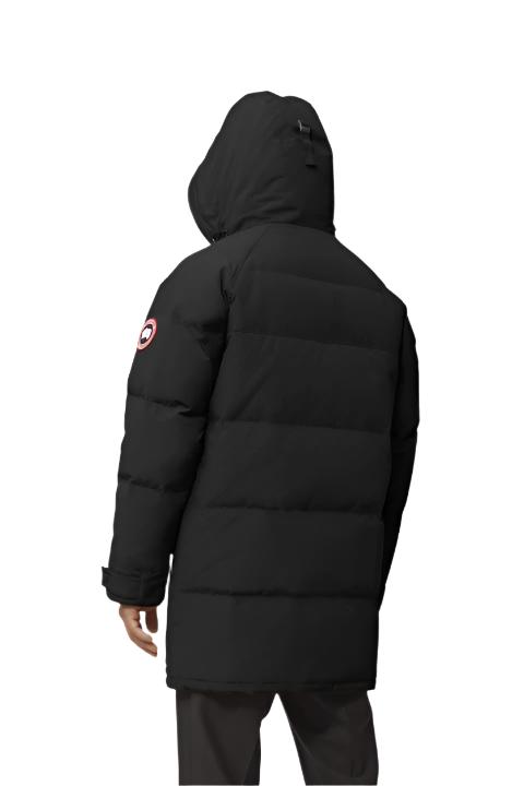 Black hooded down parka with Canada Goose logo patch on left sleeve.