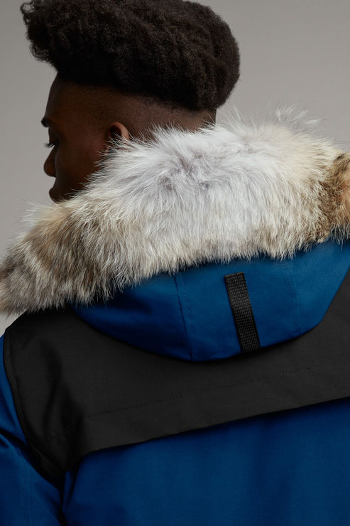 Close-up of a blue and black winter coat with a fur-trimmed hood.