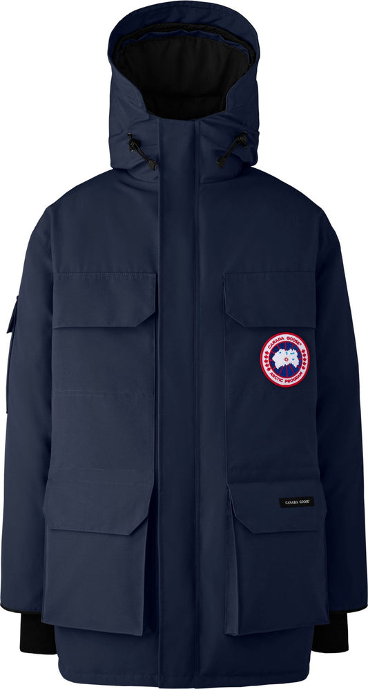 Navy blue parka with a hood, four front pockets, and a round logo patch on the left chest.