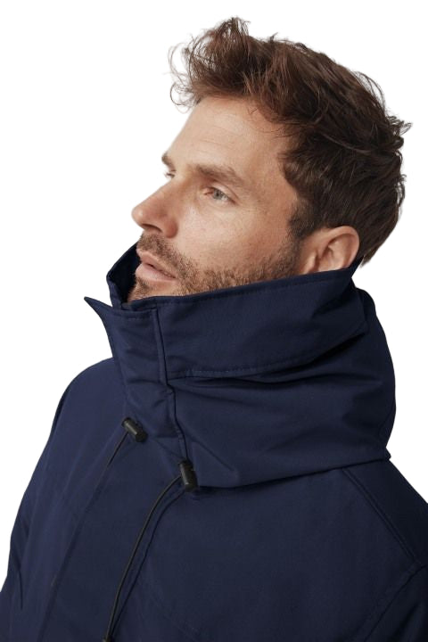 Man with beard in a navy parka with a high collar.