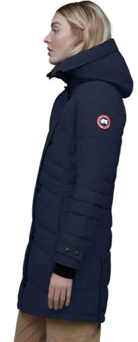 A woman wears a navy blue, down-filled parka with a hood.