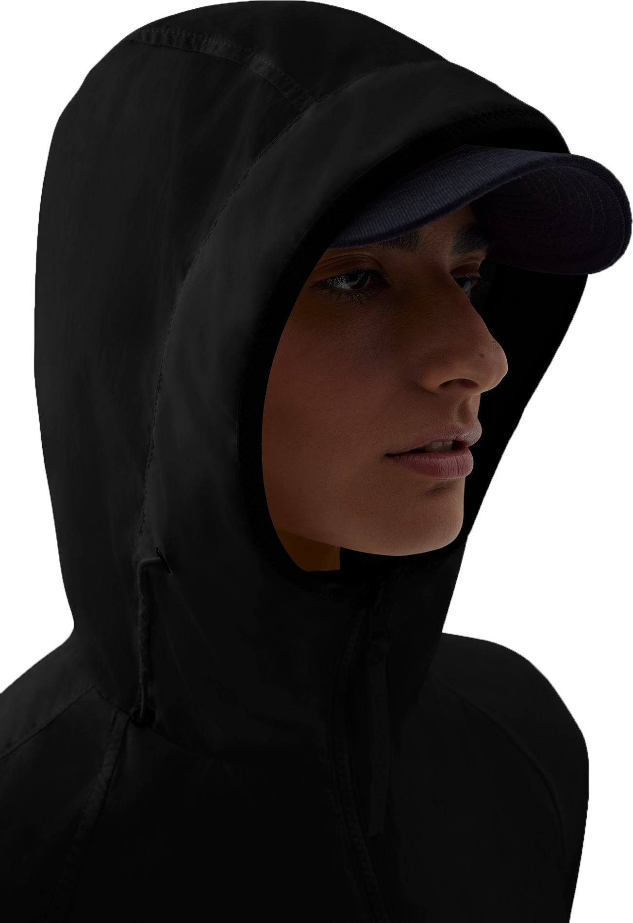 Close-up of a person wearing a black hooded garment over a baseball cap.