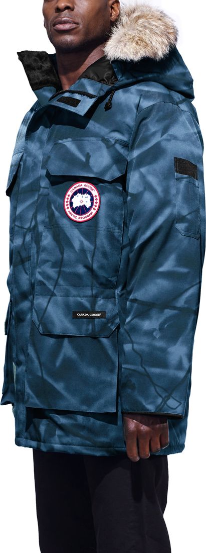 A man wearing a blue patterned parka with fur trim.