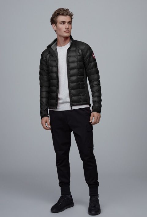 Man in black puffer jacket, white shirt, and black pants.