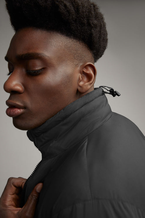 Close-up of a man in a black, high-collared jacket.
